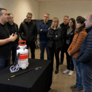 Formateur en lutte antiparasitaire présentant un pulvérisateur professionnel à des stagiaires
