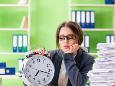 Jeune employée très occupée avec la paperasse en cours