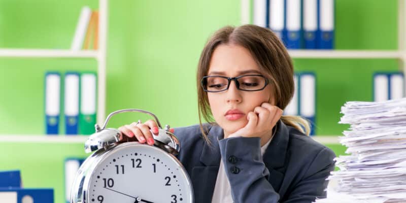 Jeune employée très occupée avec la paperasse en cours