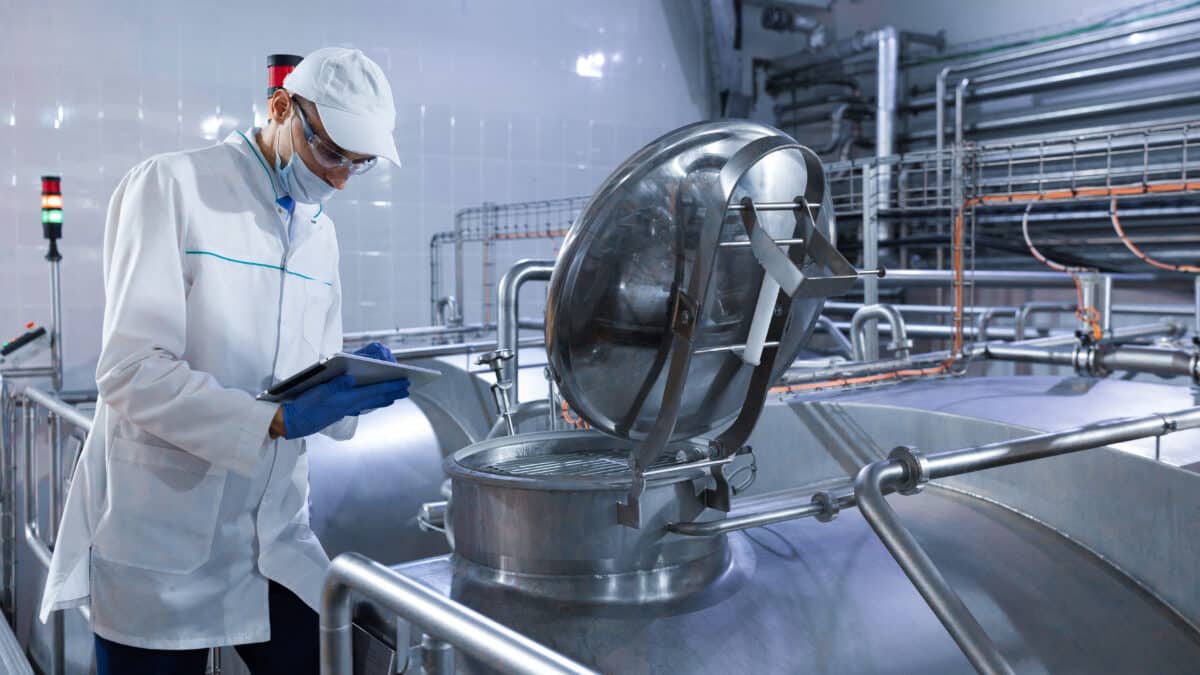 Auditeur inspectant la chaîne de production d'une usine laitière