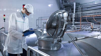 Auditeur inspectant la chaîne de production d'une usine laitière