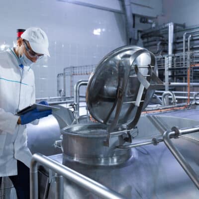Auditeur inspectant la chaîne de production d'une usine laitière