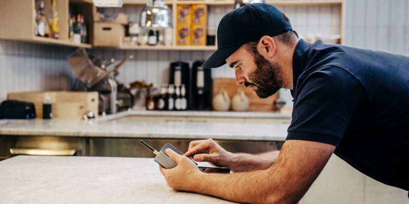 homme dans une cuisine appuyé sur une table