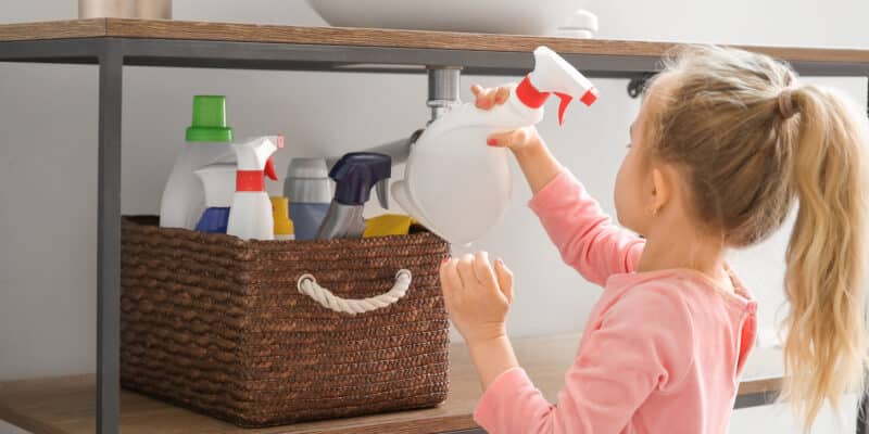 Petite fille jouant avec des produits chimiques à la maison